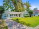 Single-story home with neat landscaping, driveway, and a backdrop of lush trees create a welcoming curb appeal at 405 Amberjack Way, Summerville, SC 29485