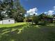 Spacious backyard featuring a shed, a covered patio, and abundant greenery at 409 Azalea Dr, Walterboro, SC 29488