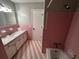 Pink tiled bathroom with a bathtub, vanity, and neutral colored walls at 409 Azalea Dr, Walterboro, SC 29488