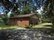 Charming brick home featuring an attached garage, green shutters, and manicured lawn at 409 Azalea Dr, Walterboro, SC 29488
