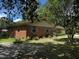 Charming brick home featuring an attached garage, green shutters, and manicured lawn at 409 Azalea Dr, Walterboro, SC 29488