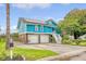 Eye-catching two-story teal home with a two-car garage, solar panels, and well-maintained landscaping at 4636 Ashley View Ln, North Charleston, SC 29405