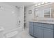 Modern bathroom featuring a tub and shower combination and a blue vanity with granite countertop at 5904 Oak Street, Hanahan, SC 29410