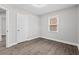 Bedroom with wood flooring, neutral walls, a window, and a traditional white door at 5904 Oak Street, Hanahan, SC 29410