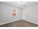 A neutral-toned bedroom with wood flooring, a window, and a classic white door at 5904 Oak Street, Hanahan, SC 29410