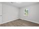 This bedroom has neutral walls, wood flooring, a ceiling fan and a window that offers outdoor views at 5904 Oak Street, Hanahan, SC 29410