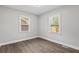 Well-lit bedroom featuring wood floors, two windows, and neutral walls at 5904 Oak Street, Hanahan, SC 29410