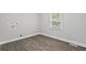 A bright, empty room with wood flooring and a window providing lots of natural light at 5904 Oak Street, Hanahan, SC 29410
