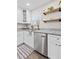 Modern kitchen with granite countertops, stainless steel dishwasher, open wood shelves, and wood flooring at 5904 Oak Street, Hanahan, SC 29410