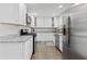 Modern kitchen featuring stainless steel appliances, white cabinets, granite countertops, and hardwood floors at 5904 Oak Street, Hanahan, SC 29410