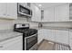 Well-lit kitchen featuring white cabinets, granite countertops, and stainless steel appliances at 5904 Oak Street, Hanahan, SC 29410