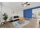 Bright living room with modern sofa, unique artwork, accent wall, and a ceiling fan for added comfort at 5904 Oak Street, Hanahan, SC 29410