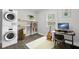 Charming home office featuring a washer and dryer unit, modern desk, neutral rug, and ample natural light at 5904 Oak Street, Hanahan, SC 29410