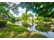 Scenic pond view surrounded by lush greenery and mature trees on a sunny day at 6275 Rolling Fork Rd # 401, North Charleston, SC 29406