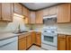 Well-equipped kitchen featuring light wood cabinetry and essential white appliances at 6280 Rolling Fork Rd # 302, North Charleston, SC 29406