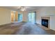 Spacious living room with a cozy fireplace, ceiling fan and sliding glass doors leading to outdoor space at 6280 Rolling Fork Rd # 302, North Charleston, SC 29406
