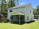 View of the rear exterior featuring a screened-in porch and large backyard at 641 Magnolia Rd, Charleston, SC 29407