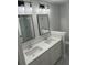 Modern bathroom featuring double sinks, quartz countertops, dark framed mirrors, and contemporary lighting at 641 Magnolia Rd, Charleston, SC 29407