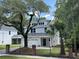 Charming two-story home featuring a two-car garage, white exterior, and a beautiful mature tree and palm tree in the front yard at 641 Magnolia Rd, Charleston, SC 29407