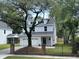 Charming two-story home featuring a two-car garage, white exterior, and a beautiful mature tree in the front yard at 641 Magnolia Rd, Charleston, SC 29407