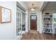 Bright foyer featuring hardwood floors, a charming bookshelf, and access to a storage area at 72 Crossandra Ave, Summerville, SC 29483