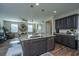 Open layout with kitchen island, stainless appliances, granite counters, and view into the well-lit living room at 72 Crossandra Ave, Summerville, SC 29483