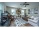 Bright living room featuring a ceiling fan, modern furnishings, and a large decorative wall clock at 72 Crossandra Ave, Summerville, SC 29483