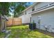 The backyard features an air conditioning unit, grass, a wood fence and exterior lights at 7814 Nummie Ct, North Charleston, SC 29418