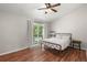 Bedroom with wood floors, ceiling fan, and glass doors to a balcony overlooking trees at 7814 Nummie Ct, North Charleston, SC 29418