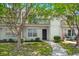 Charming two-story condo with white siding, a walkway, mature trees, and a private second-story balcony at 7814 Nummie Ct, North Charleston, SC 29418