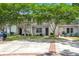 Charming two-story condo with white siding, a walkway, mature trees, and a private second-story balcony at 7814 Nummie Ct, North Charleston, SC 29418