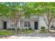 Charming two-story condo with white siding, a walkway, mature trees, and a private second-story balcony at 7814 Nummie Ct, North Charleston, SC 29418