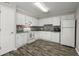 Bright kitchen features white cabinetry, appliances, a multicolored backsplash, and wood-look flooring at 7814 Nummie Ct, North Charleston, SC 29418