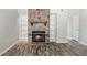 Living room with a stone fireplace, built-in shelving, and wood-look flooring, creating a cozy atmosphere at 7814 Nummie Ct, North Charleston, SC 29418