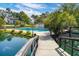 The neighborhood pool is surrounded by green foliage, a lake and community buildings at 7814 Nummie Ct, North Charleston, SC 29418