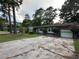 Brick single-story house with a long concrete driveway, attached garage and mature trees at 8334 Witsell St, North Charleston, SC 29406