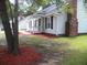 Charming single-story home featuring a manicured front yard, classic architectural details, and brick chimney at Way, Goose Creek, SC 29445