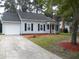 Charming single-story home featuring a garage, manicured front yard, and classic architectural details at Way, Goose Creek, SC 29445
