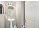 Clean half bathroom featuring a pedestal sink, oval mirror, and neutral wall color at 1005 Yellow Hawthorn Circle, Summerville, SC 29483