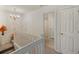 Hallway with carpet floors, white walls and railing, and chandelier at 1005 Yellow Hawthorn Circle, Summerville, SC 29483