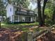 Two-story home with a spacious balcony and a large yard enclosed by a rustic wooden fence at 102 Webb St, Bonneau, SC 29431