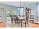 Open-concept dining area with hardwood floors, stylish lighting, and backyard views at 104 Study Ct, Ladson, SC 29456