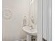 Stylish powder room with pedestal sink, decorative mirror, and elegant wall art at 105 Brockman Way, Goose Creek, SC 29445