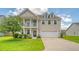 Charming two-story home featuring a welcoming front porch, attached two-car garage, and well-manicured lawn at 109 Cypress Plantation Rd, Moncks Corner, SC 29461