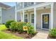 Inviting front porch with a sunflower wreath, complemented by lush landscaping at 109 Cypress Plantation Rd, Moncks Corner, SC 29461