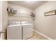 Functional laundry room with a washer, dryer, shelving, and tile flooring, making laundry chores convenient and efficient at 109 Cypress Plantation Rd, Moncks Corner, SC 29461