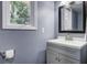 Well-lit bathroom features a gray vanity with a white countertop, window view, and a framed mirror at 112 Lewisfield Dr, North Charleston, SC 29418