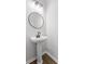 This powder room is nicely appointed with a round mirror, pedestal sink, and sleek faucet at 113 Amaranth Ave, Summerville, SC 29483