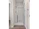The renovated walk-in shower features an open glass door, modern fixtures and pristine white tile at 113 Amaranth Ave, Summerville, SC 29483