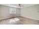 A sunny bedroom featuring gray plank flooring, a large window, and a modern ceiling fan at 113 Harvey Ave, Goose Creek, SC 29445